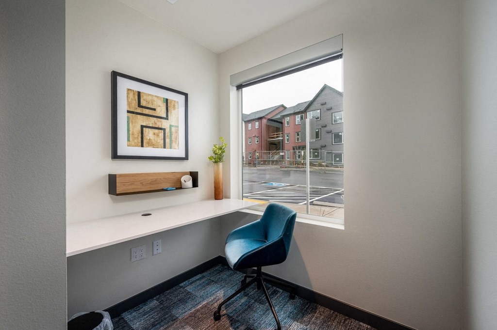 room with a desk and a window with a street view