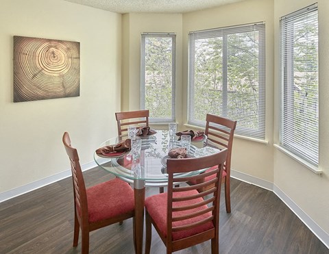a dining room with a glass table and chairs