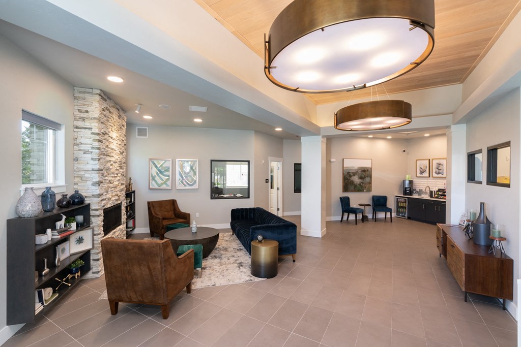 a living room with couches and chairs and a stone fireplace