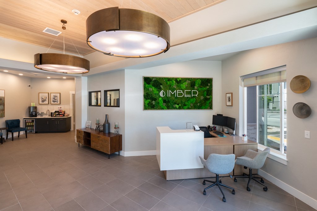 a reception area with a desk and chairs and a green wall on the wall above