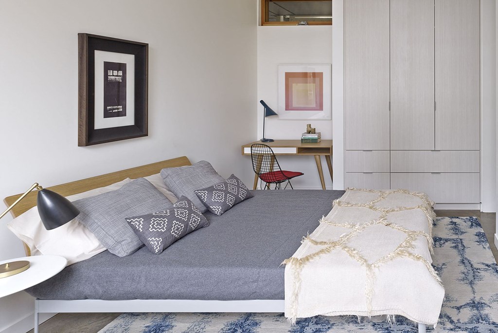 a bedroom with a bed and pillows and a desk