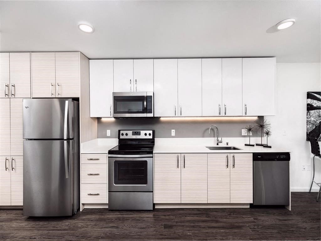 a kitchen with white cabinets and stainless steel appliances