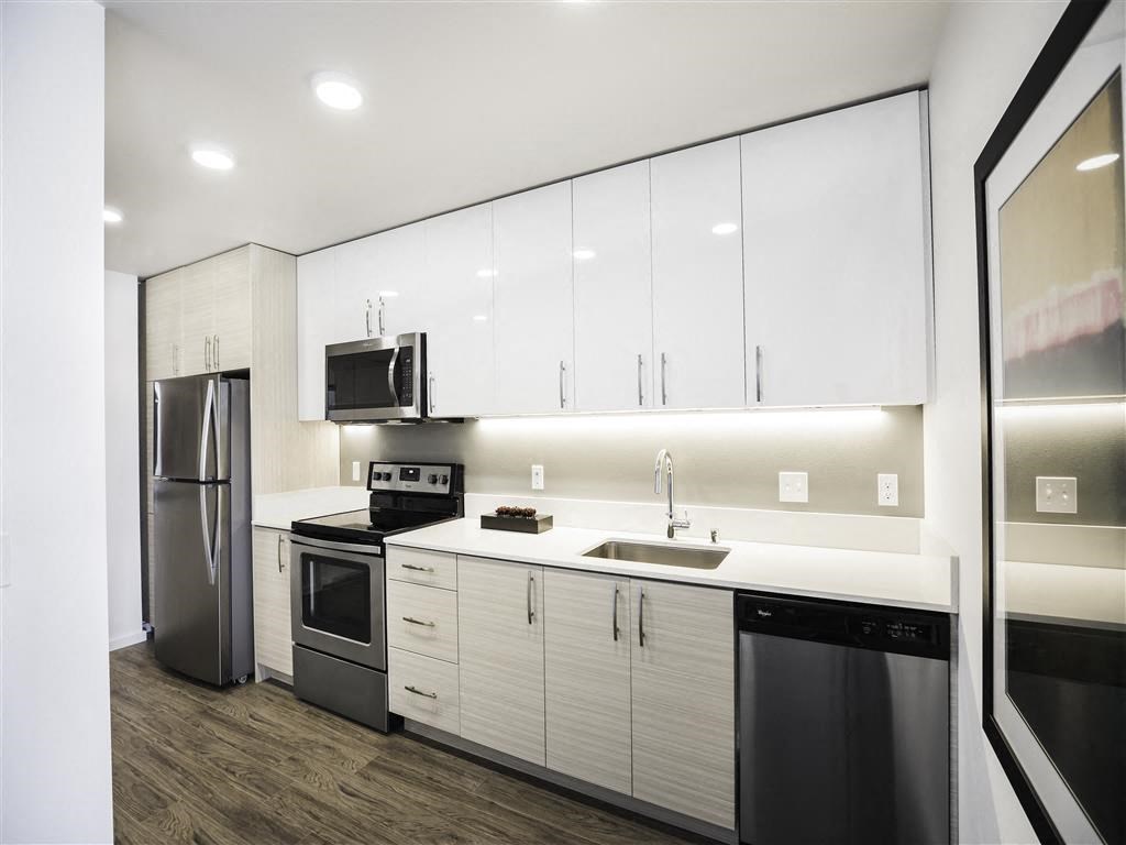 a kitchen with white cabinets and a stainless steel refrigerator