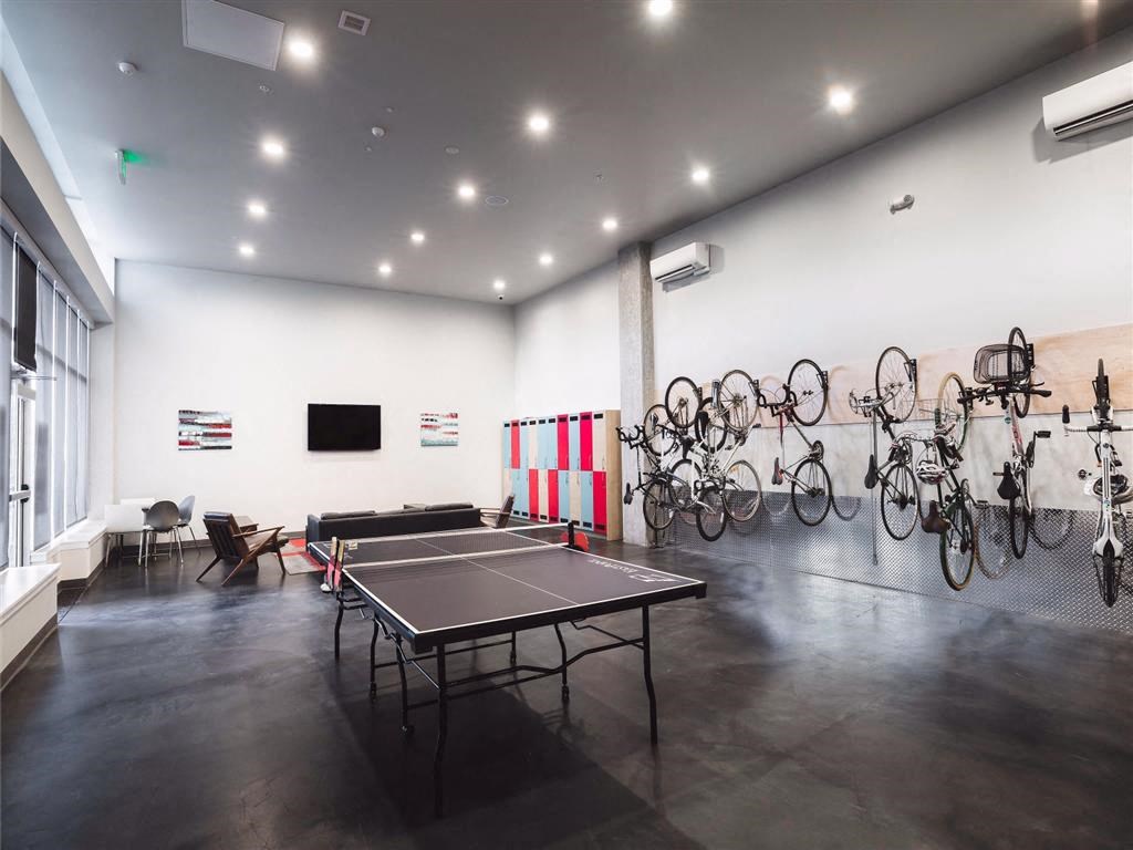 a room with a ping pong table and bicycles on the wall