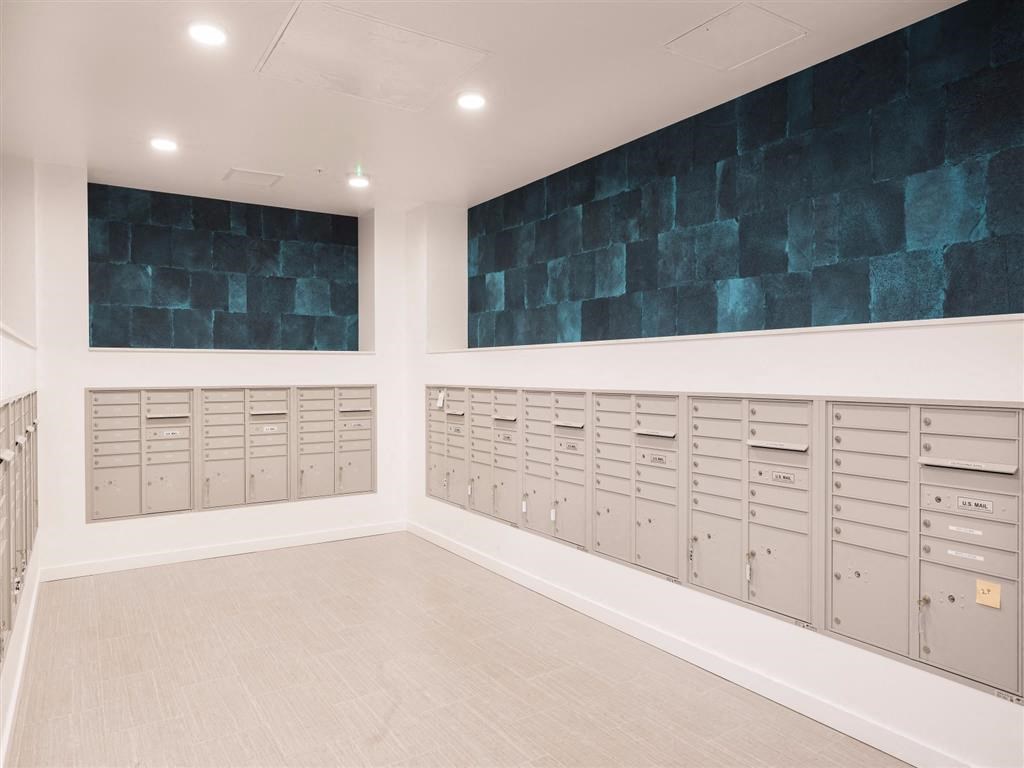 the locker room at the gym has plenty of lockers and a blue accent wall