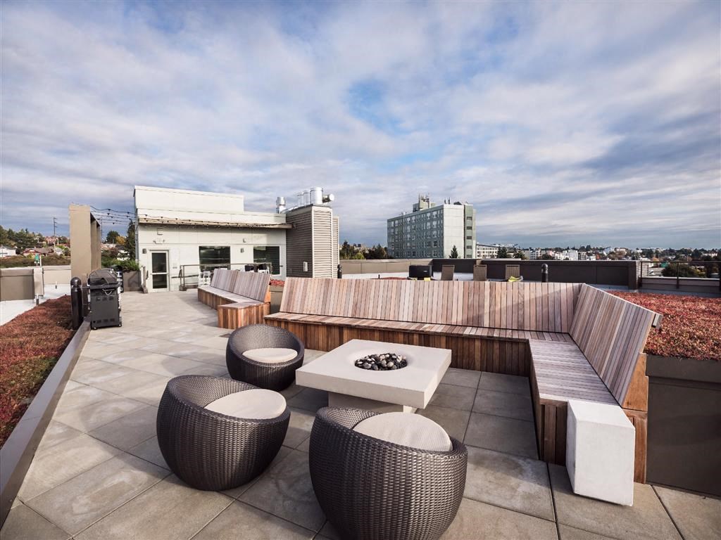 a roof terrace with furniture and a city in the background