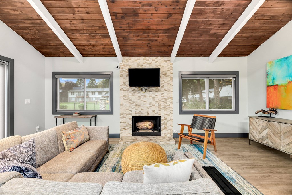 A living room with a fireplace and a television on the wall.
