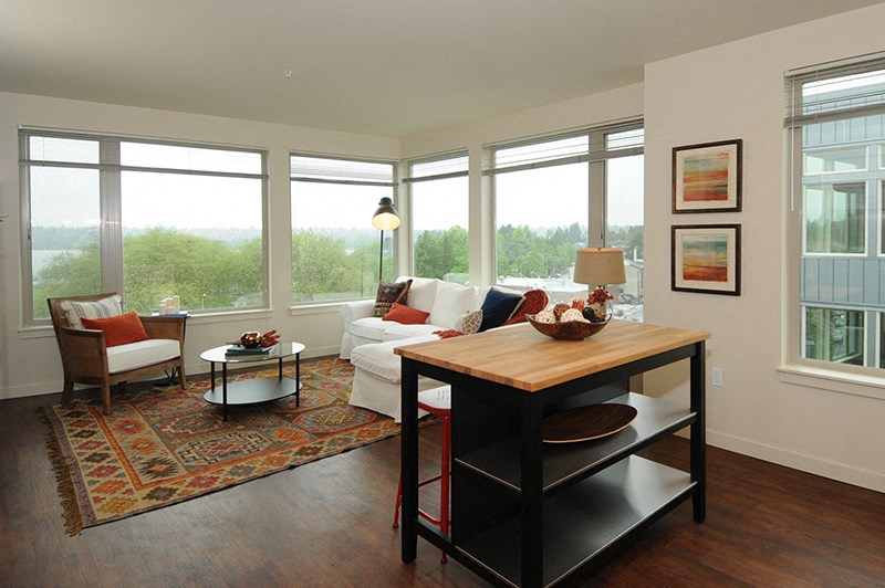 a living room with a table and a couch in front of large windows