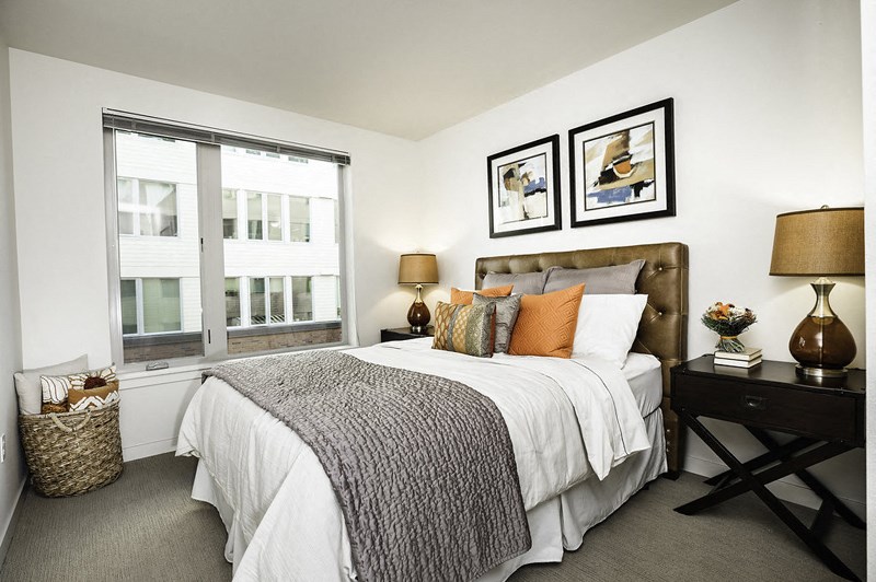 a bedroom with a bed and two windows