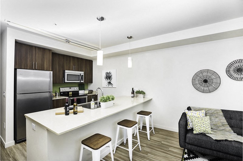 an open kitchen with a bar and a living room