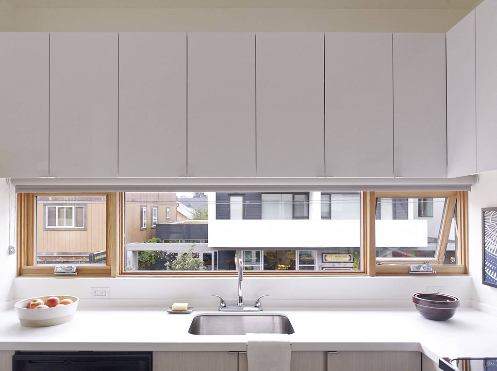 a kitchen with white cabinets and a sink and a window