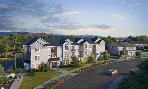 A large apartment complex with a parking lot in front.