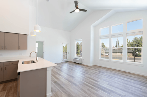 A spacious kitchen with a white countertop and wooden flooring.