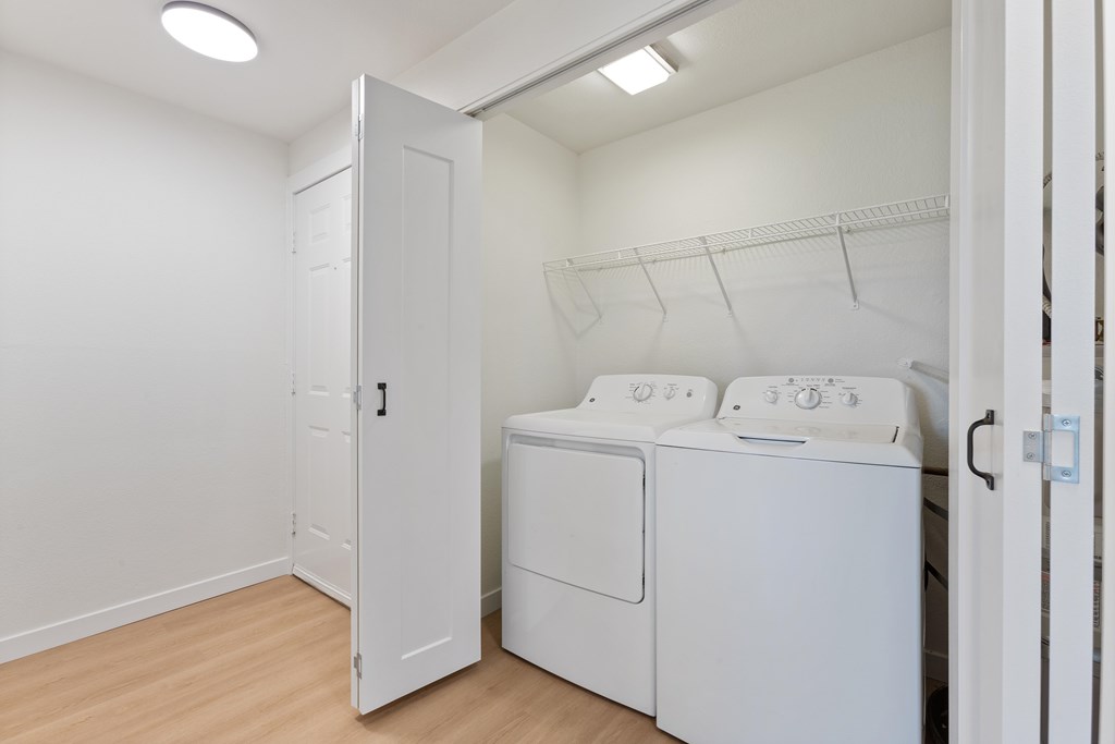 A white laundry room with a washer and dryer.