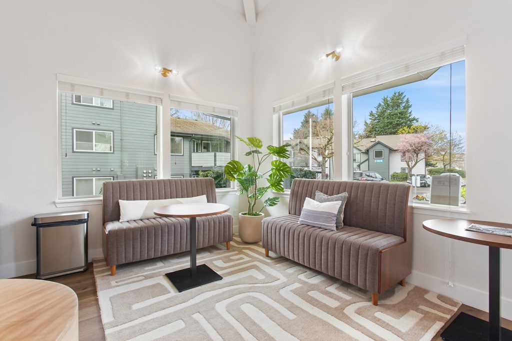 A living room with a grey couch and a rug.