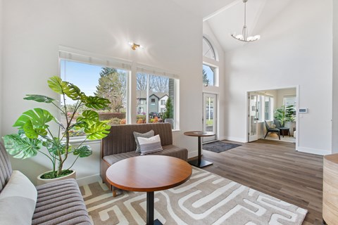 A living room with a grey couch, a brown table, and a rug with a geometric pattern.