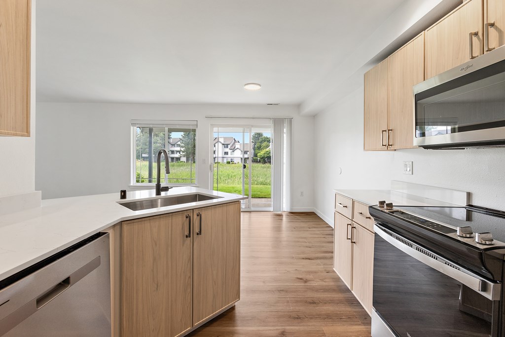 A modern kitchen with wooden cabinets and stainless steel appliances.