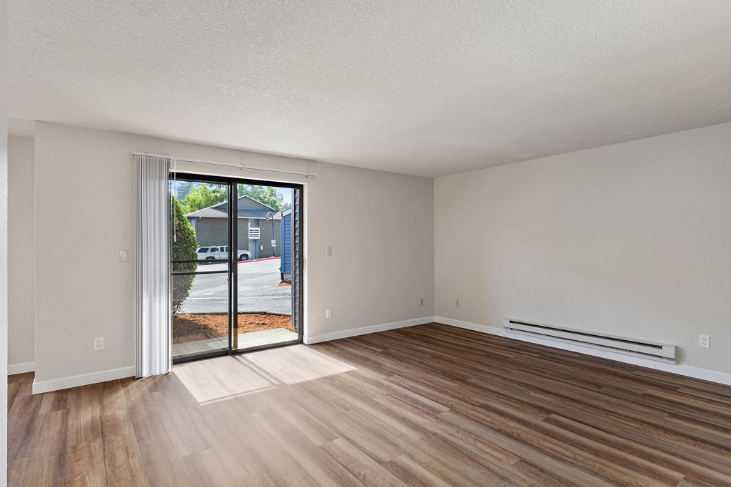 A room with a sliding glass door leading to a street.