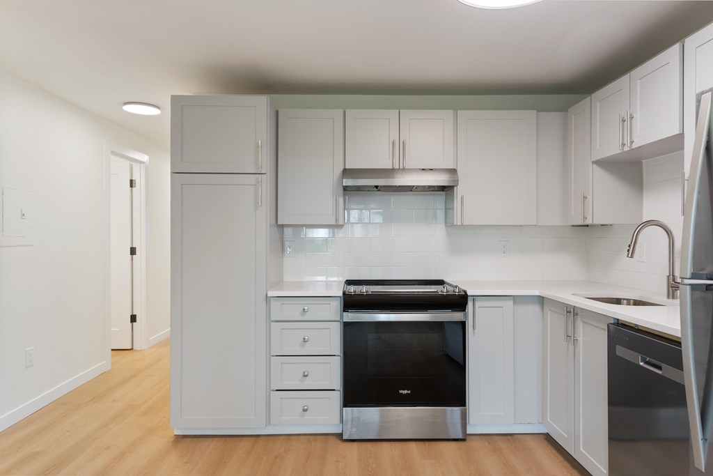 A kitchen with white cabinets and stainless steel appliances.