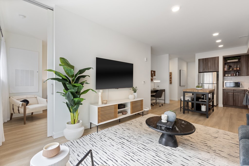 A modern living room with a flat screen TV and a coffee table.
