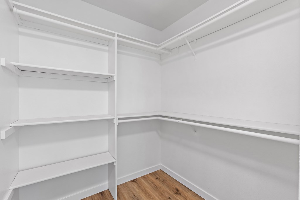 Empty white shelves in a room with wooden flooring.