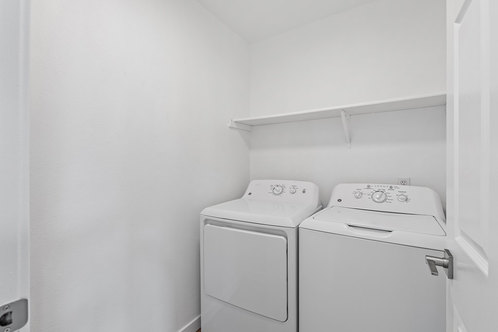 A white laundry room with a washer and dryer.