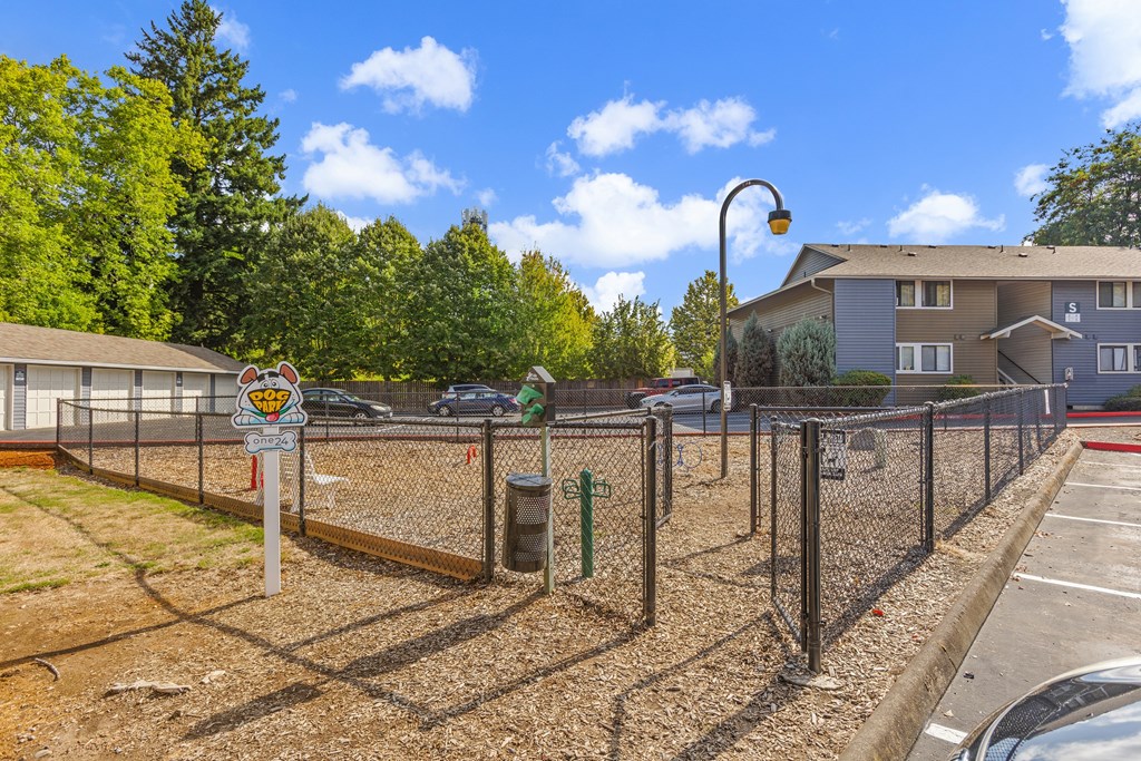 A sign with a smiley face is attached to a pole in front of a chain link fence.