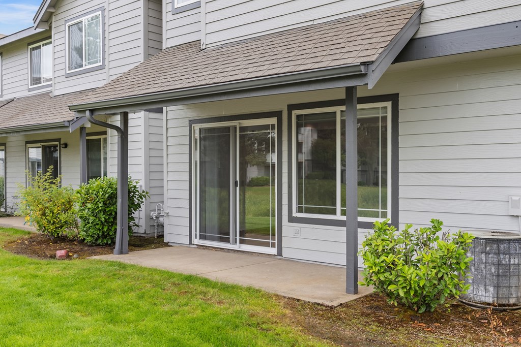 A house with a grey siding and a brown roof.