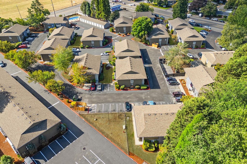 A bird's eye view of a residential area with houses and a parking lot.