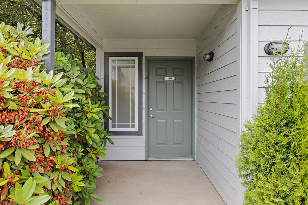 A grey door is on the right side of a white wall.