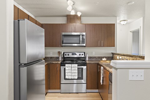 A modern kitchen with a stainless steel refrigerator and a stove top oven.