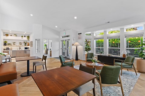 A modern living room with a wooden table and green chairs.