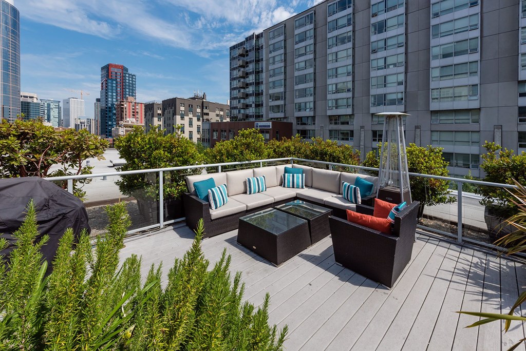 a seating area on a roof terrace with a view of the city