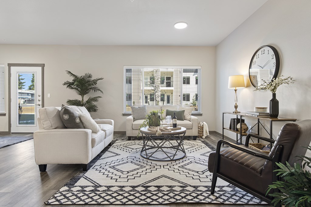 A living room with a white couch, a coffee table, and a large window.