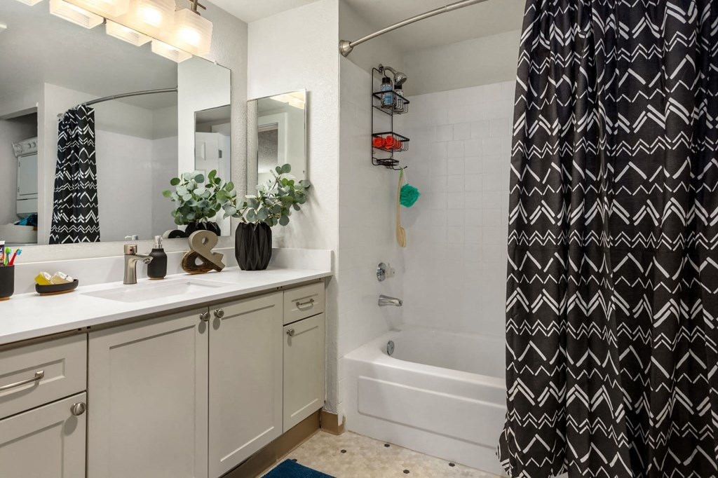 a bathroom with a black and white shower curtain