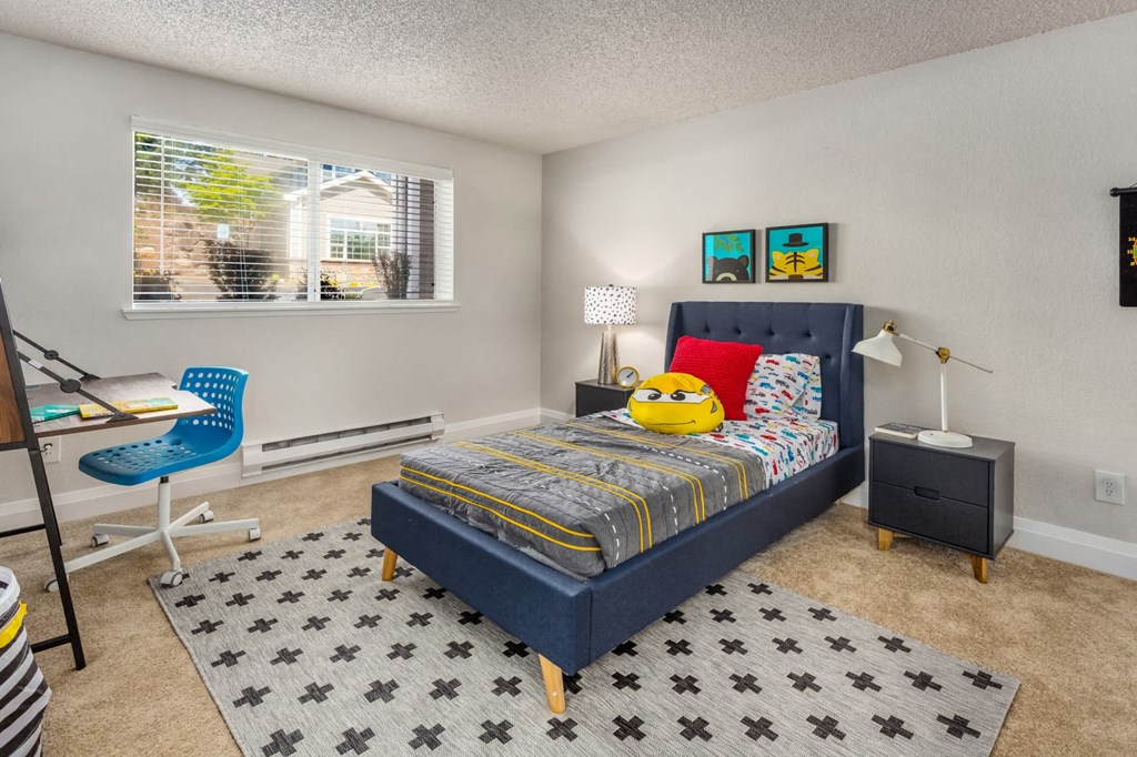 a bedroom with a bed and a desk and a window