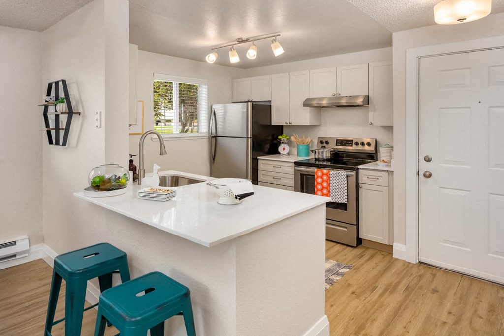 a kitchen with a white counter top with blue stools