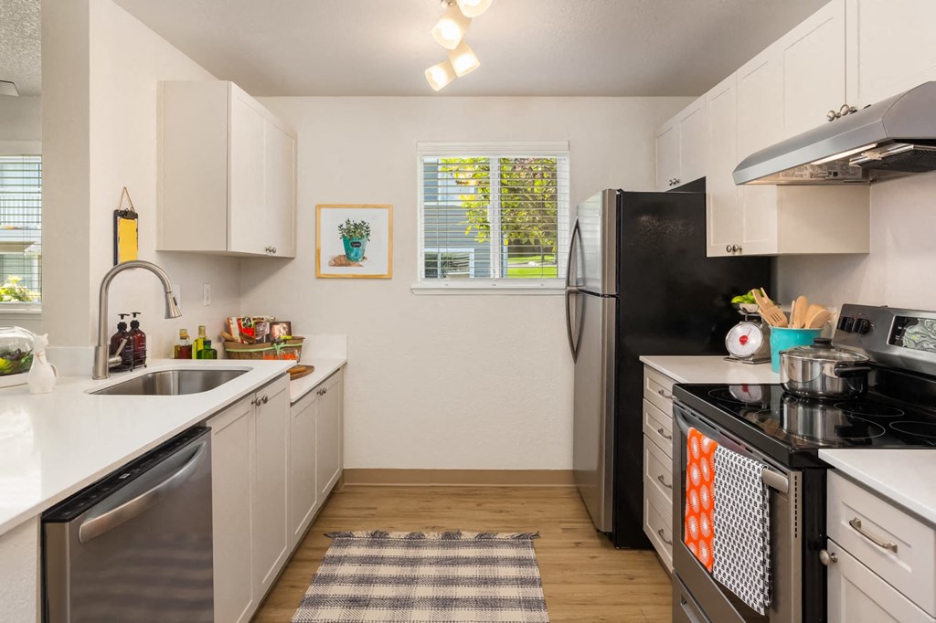 a kitchen with stainless steel appliances and white cabinets