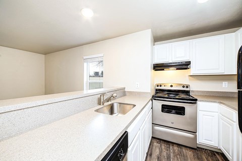a kitchen with white cabinets and stainless steel appliances