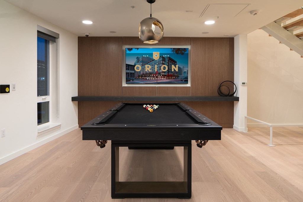 a game room with a pool table and a movie on the wall