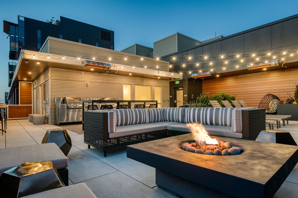 a patio with a fire pit and seating around it
