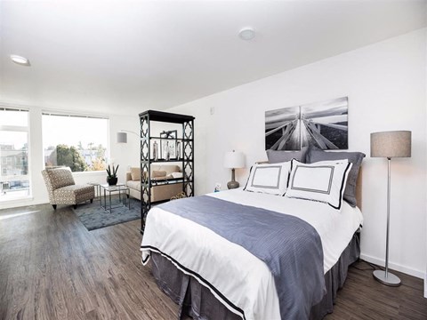A bedroom with a large bed and a chair.