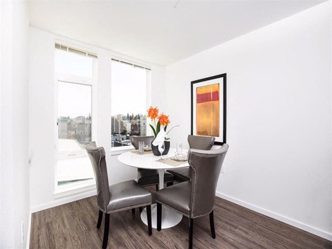 A dining room with a table and chairs.