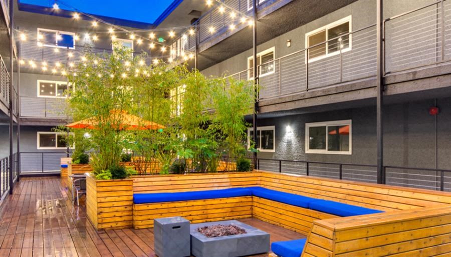 a large patio with a wooden deck and a blue pool
