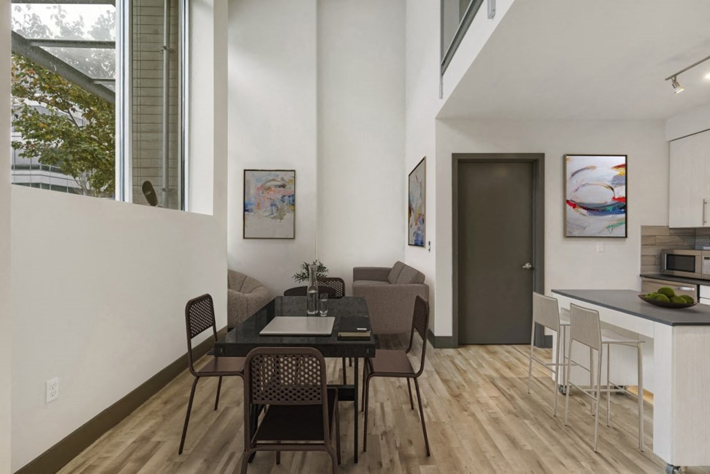 a dining area with a table and chairs and a kitchen in the background