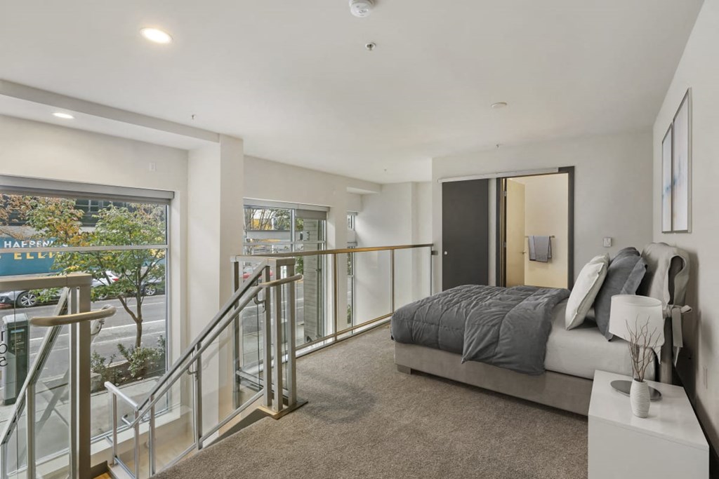 a bedroom with a bed and a staircase in front of it