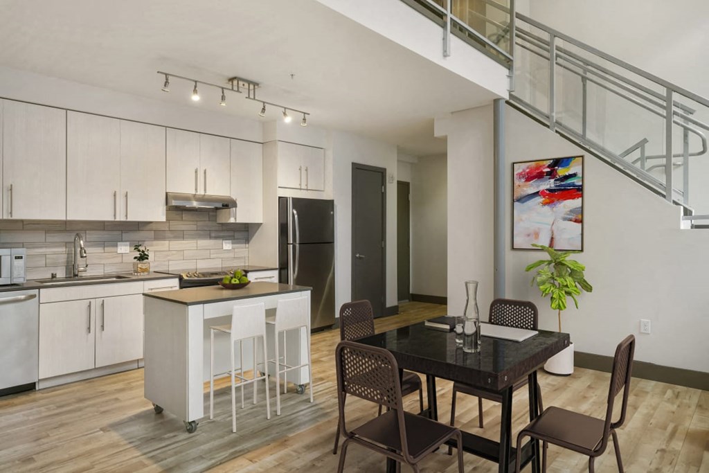 an open kitchen and dining area with a staircase in the background