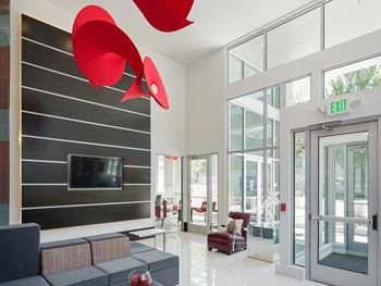 a living room with a couch and chair and a tv on the wall