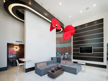 a modern living room with a large red flower chandelier hanging from the ceiling