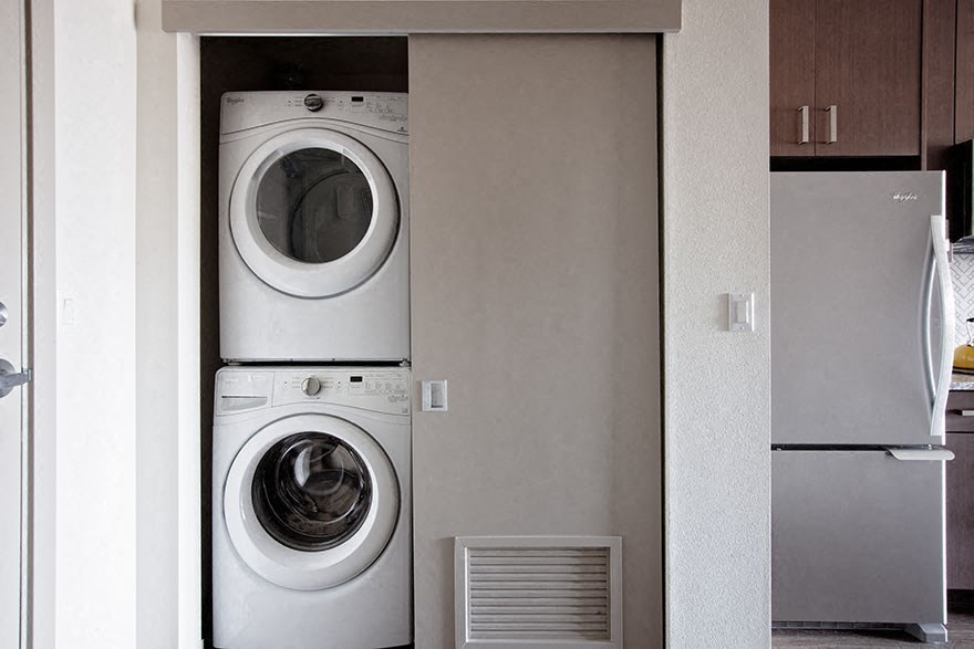 a washer and dryer in a kitchen next to a refrigerator